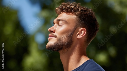 Young caucasian male enjoying sunlight outdoors in nature scene
