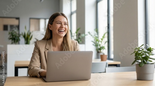 Happy confident professional working on laptop in modern workspace
