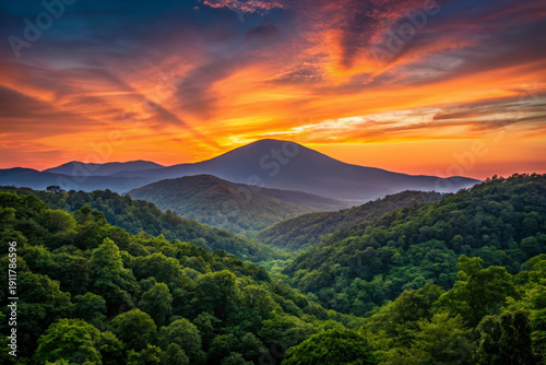 Spectacular Sunset Over Lush Green Mountain Valley with Fiery Orange and Red Sky