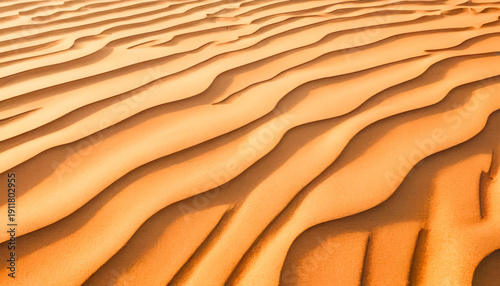 golden sand dunes with repeating wave patterns in desert landscape showing warm sunlight texture natural minimal scenery travel adventure concept and peaceful vast environment under clear sky with det