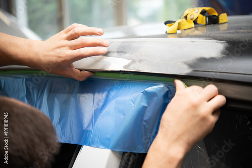 Hands Applying Protective Film on Car Panel Before Primer