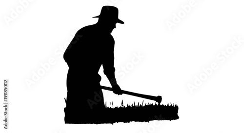 Silhouette of a person mowing the lawn at dusk