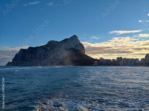 Ethereal fog surrounds solitary rock as calm sea reflects early morning safety and harmony