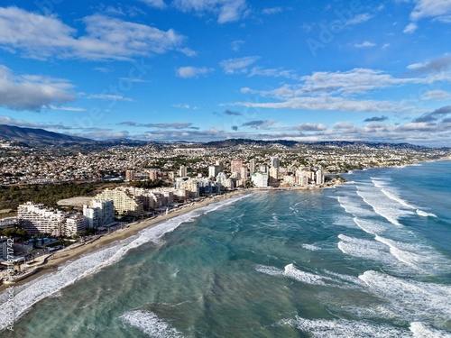 Canvas-taulu Bustling coast with shimmering waves, Lively oceanfront scene with energetic wav
