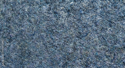 Macro top view of sustainable recycled denim insulation board texture. Indigo and blue-grey organic fibers with a felt-like tactile surface. Eco-friendly textile waste material with copy space
