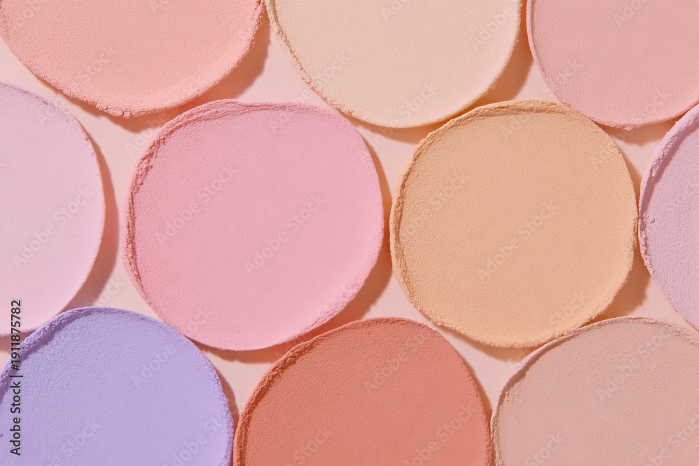 Fototapeta premium Soft colored circles arranged on a flat surface create a playful scene during daytime light