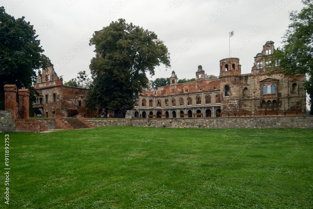 Fototapeta premium Lush Green Area. Vast Grassy Field Leading To Historic Buildings With Scenic And Cultural Significance