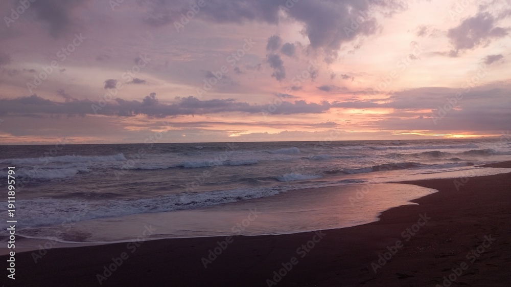 Fototapeta premium Dramatic ocean sunset with crashing waves and glowing horizon, ideal for travel promotion, relaxation themes, nature backgrounds, cinematic storytelling.