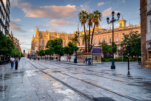 Seville Cathedral at sunset with people walking, architecture in the Spanish city, Andalusia.