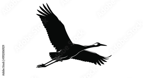Elegant black silhouette of a large crane or stork in mid-flight, with its powerful wings spread and long legs trailing.