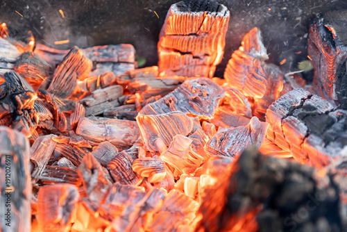 Hot red coals burn brightly. BBQ wood on fire.