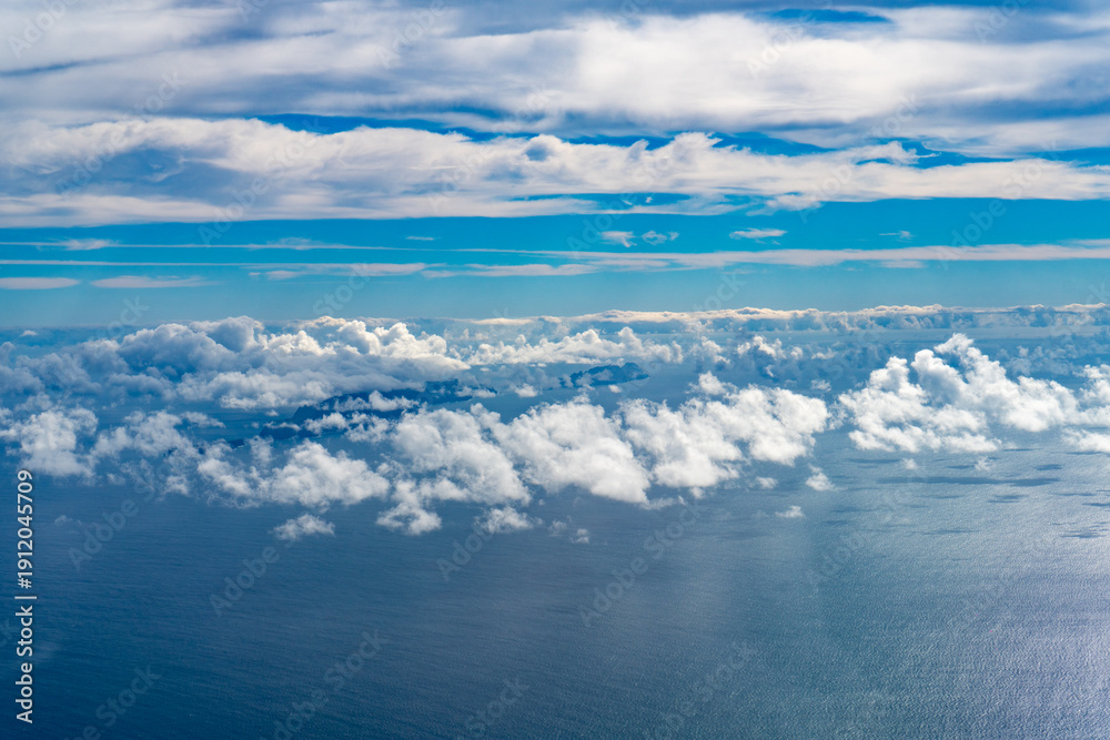 Naklejka premium Aerial view of islands through white clouds.