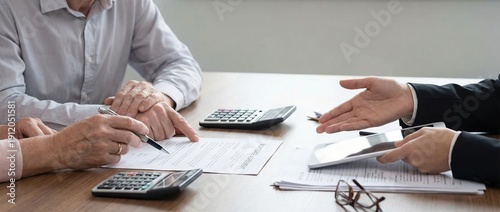 Elderly couple buying home insurance with real estate agent office meeting mortgage advice professional environment