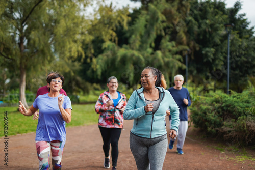 Group of multiracial senior friends running at city park - Fit elderly people having fun doing sport endurance workout together outdoor