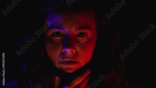 Portrait of a worried woman in red light