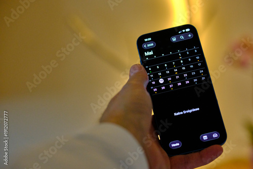 Handy Iphone in der Hand mit Kalender 