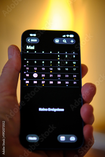 Handy Iphone in der Hand mit Kalender 