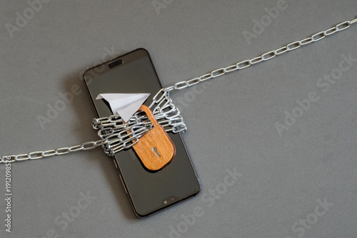 Foto A smartphone wrapped in chains with a lock, data security and restricted digital access to online platforms, social media
