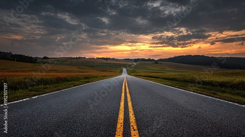 Open Road at Sunset: An endless stretch of road vanishes into the horizon, kissed by the warm embrace of the setting sun, while a sky of dramatic clouds sets the scene for a journey of a lifetime.