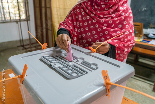 Woman casting vote in ballot box. 13th Bangladesh General Election and National Referendum. Transparent Ballot Box at a Polling Station