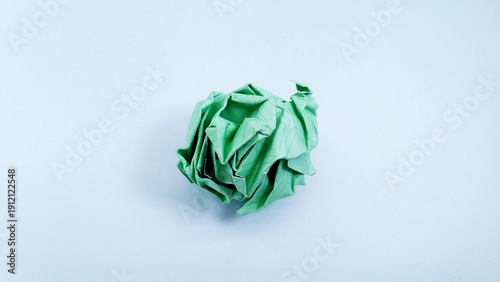 Close up of a vibrant tosca crumpled paper ball, symbolizing a discarded idea, mistake, or creative block, isolated on a clean white background. Concept of brainstorming, frustration, and recycling.