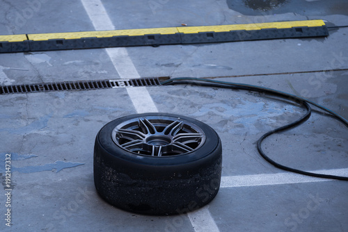 Photos Mechanic performs automotive maintenance on red race car wheel and tire