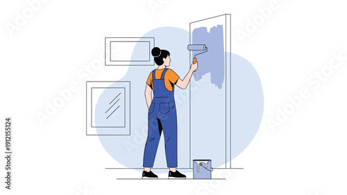 Focused young woman painting an interior wall with a blue roller while wearing denim overalls and an orange shirt in a minimalist room.
