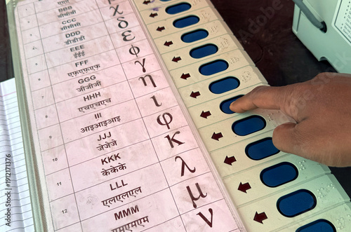 Person presses a button on an Electronic Voting Machine (EVM)