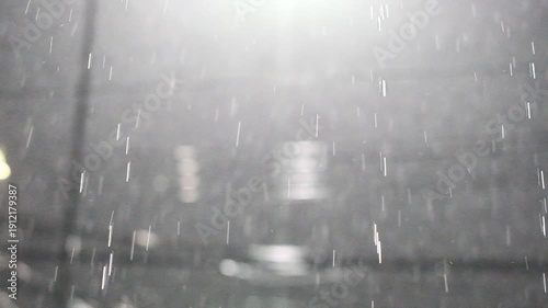 A rainy day with raindrops falling from the sky. The rain is falling in a steady stream, creating a sense of calm and tranquility. The gray sky and wet ground give the scene a moody