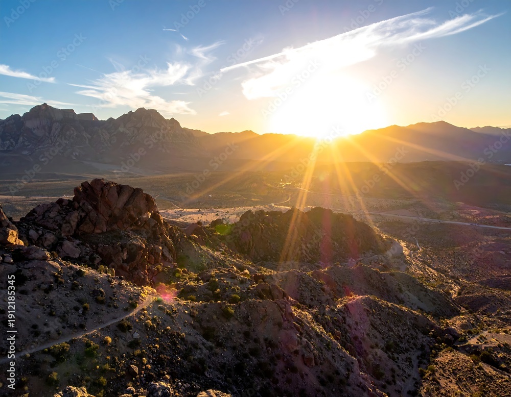 Obraz premium Sunrise illuminates distant mountain range, casting long rays