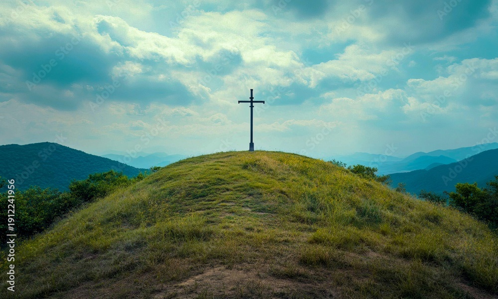 Obraz premium Christian Cross on a Grassy Mountain Peak with a Blue Cloudy Sky and Scenic Vista