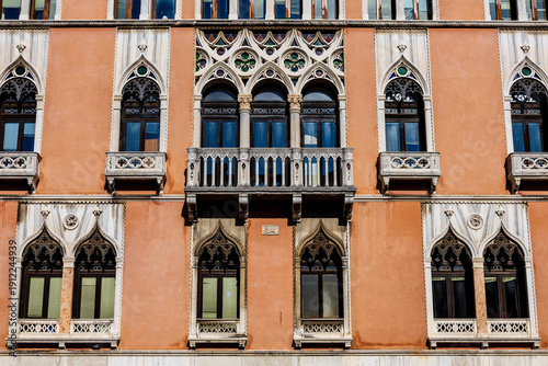 Detail of many decorated windows on a historic house in Venice