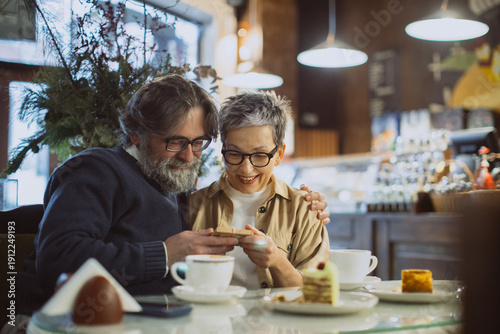 Foto Mature couple sharing happy moment in cafe