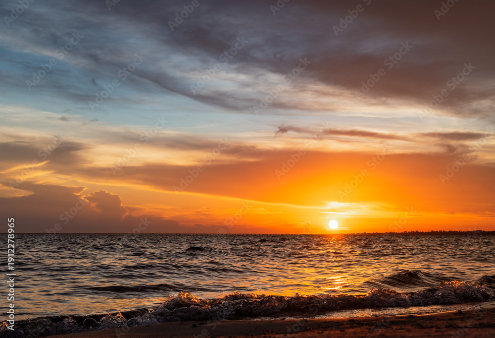 Obraz premium Serene Sunset over Rolling Waves