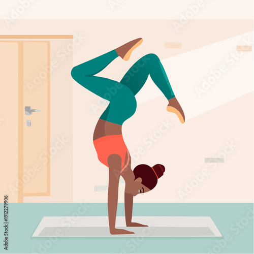 Woman performing a handstand yoga pose on a mat in a well-lit room