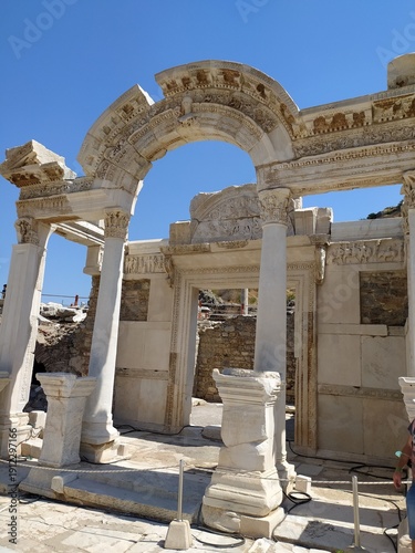 The beautifully preserved Hadrian Gate stands within the ruins of Ephesus.
Built in honor of Roman Emperor Hadrian, it showcases elegant Roman architecture.
The marble monument remains one of the most