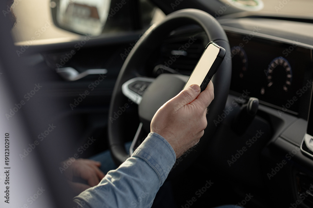 Naklejka premium Driver using smartphone while holding steering wheel. control, fines, new technologies