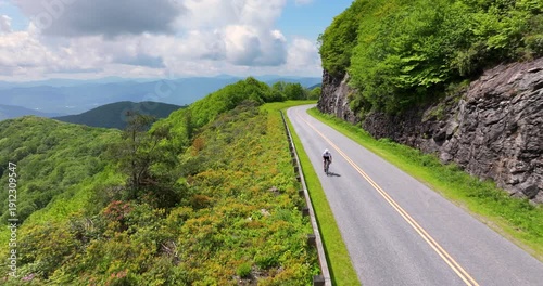 Cyclist riding a road bike along a scenic route in Appalachian Mountains, blending athletic performance, travel inspiration and outdoor exploration.