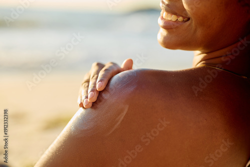 Fotografi Woman applying sunscreen to her shoulder, protecting skin from sun exposure duri