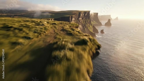 Aerial drone shot over breathtaking cliffs of moher in ireland at sunset featuring rugged rocky coastline and atlantic ocean wave