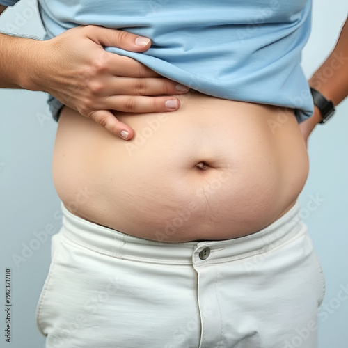 Close-Up of Man Grabbing Belly Fat, Demonstrating Weight Gain and Body Image Concerns