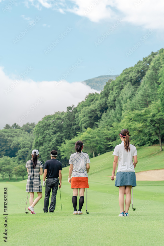 Obraz premium Male and female golfers walking on the golf course