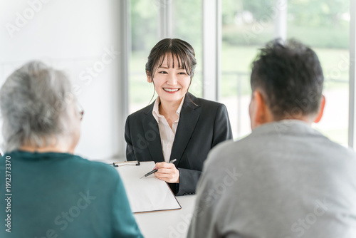 Fotografie A businesswoman explaining, proposing, guiding and recommending to an elderly co