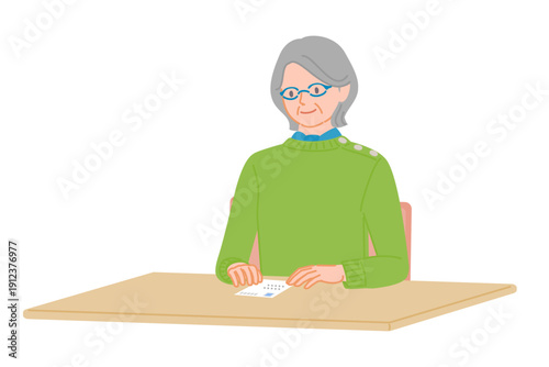 Senior woman checking postcard placed on desk