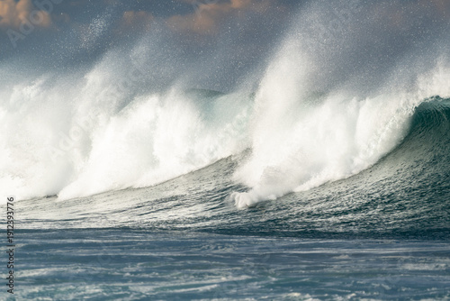 Canvas Print Massive crashing waves spray foam under dramatic cloudy skies