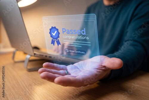 Male hand displaying virtual screen with passed exam results and congratulations message near laptop