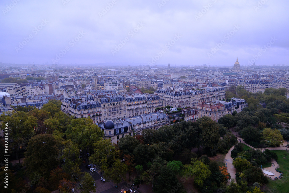 Fototapeta premium High-angle view of Paris cityscape under an overcast sky featuring Haussmann architecture and Les Invalides