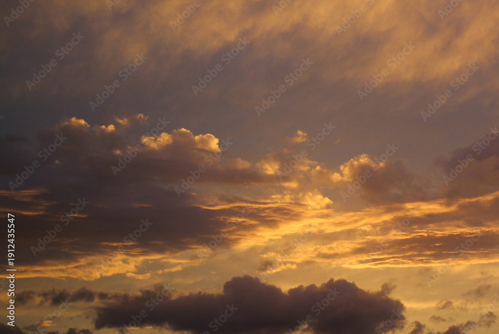 Fototapeta premium Contrasting orange and purple cloud formations, framed horizontally