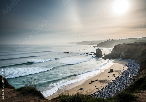 Dramatic coastal panorama with surf and sea stacks beneath hazy sunlight