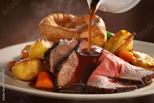 Slices of Rare Roast Beef with Yorkshire Pudding and Vegetables Served on a White Plate